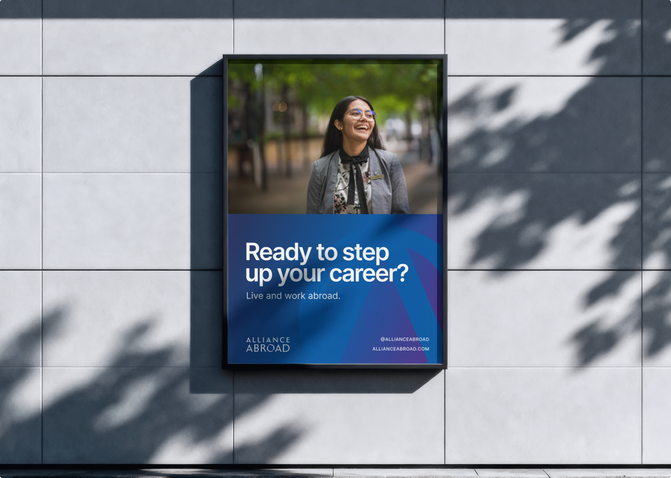 A poster on an outdoor wall shows a smiling person in business attire with the text, Ready to step up your career? Live and work abroad with Simpl by Rob&Paul. The Alliance Abroad logo and contact information are displayed.