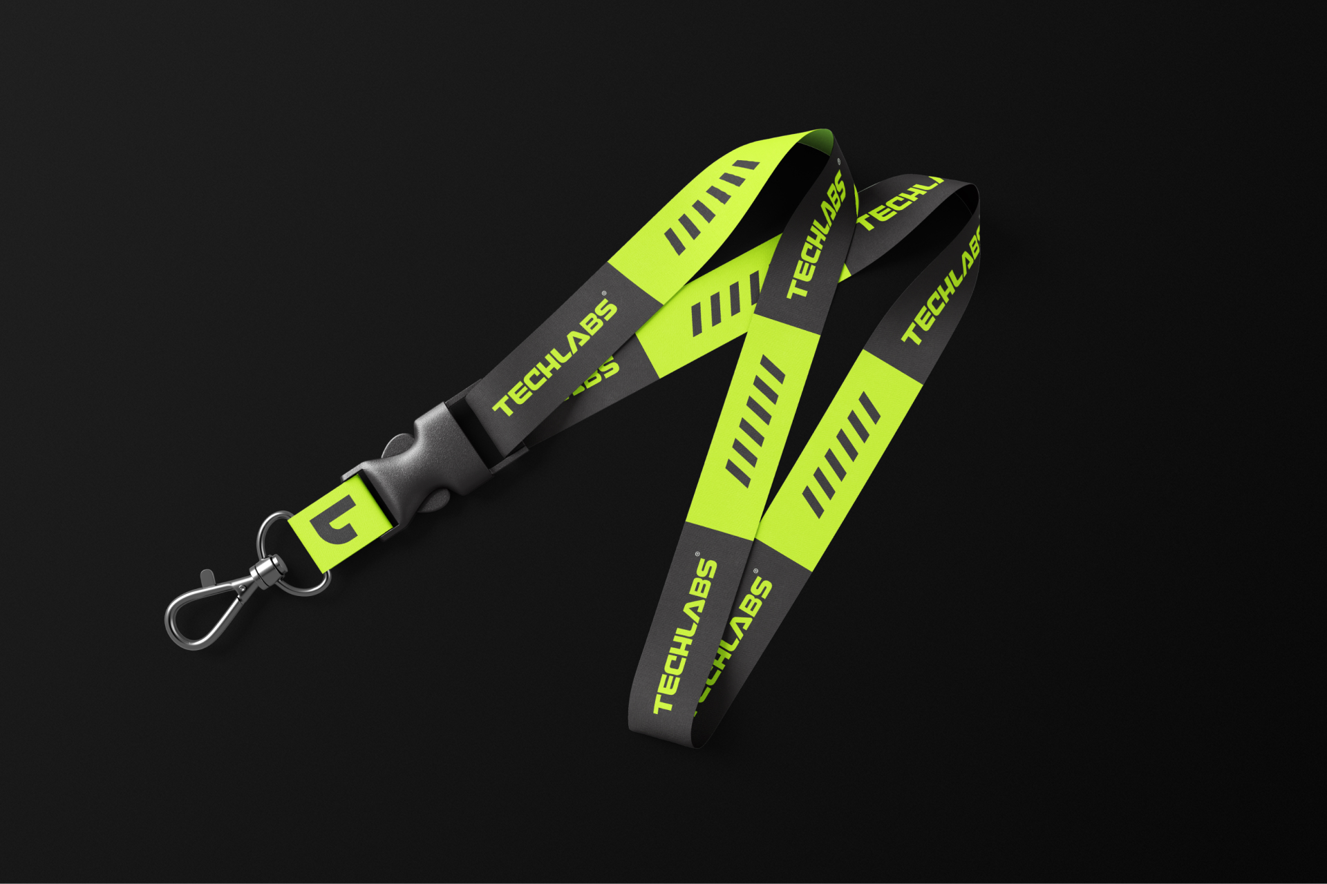 A black and neon green lanyard with the word TECHLABS and diagonal stripes printed repeatedly, featuring a metal clasp and plastic buckle, displayed on a plain black background.