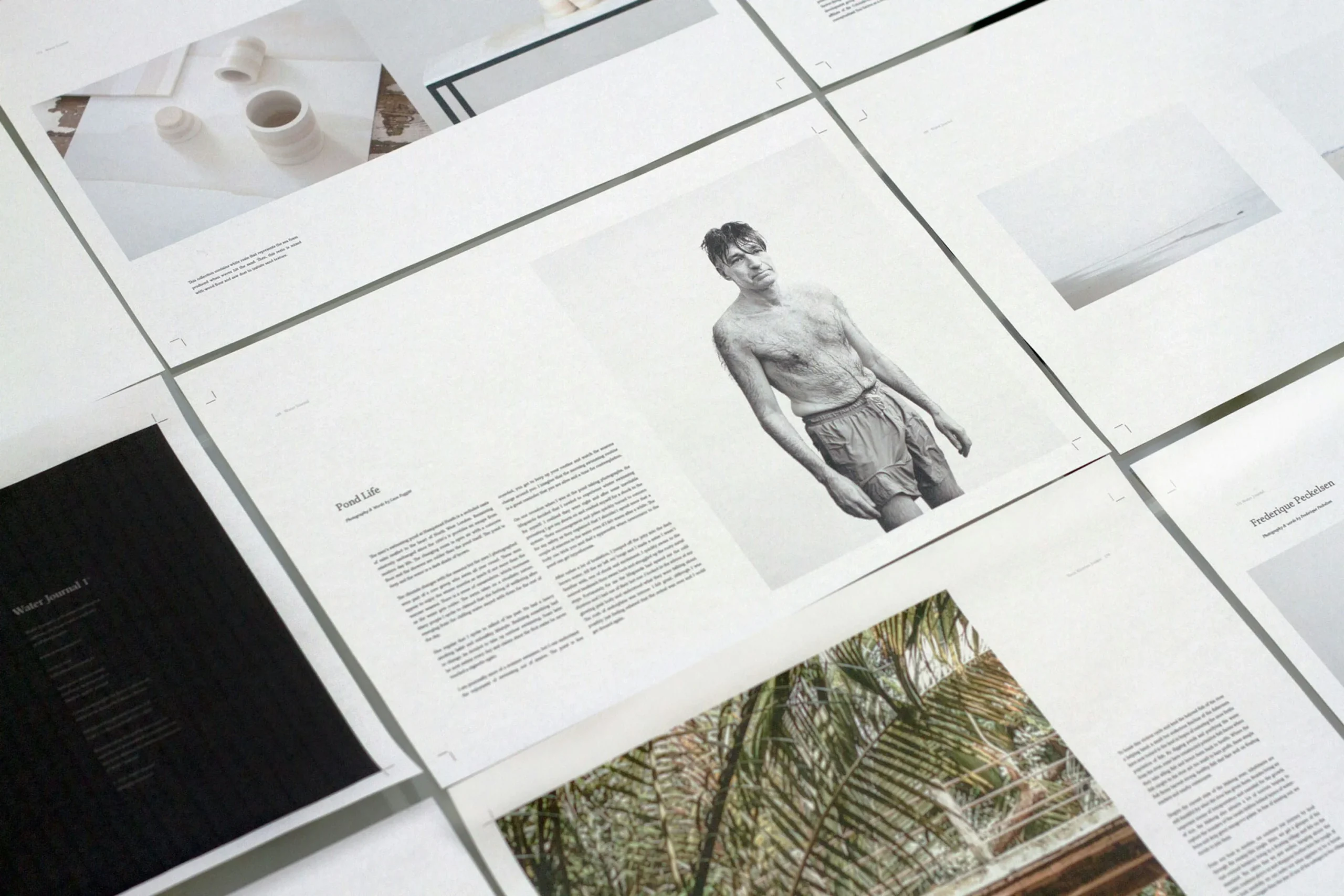 Several open magazine spreads of Simpl by Rob&Paul are laid out on a flat surface, featuring minimalist layouts with photos, text blocks, and wide margins. Prominent images include a black-and-white portrait of a man in swimwear and nature scenes.