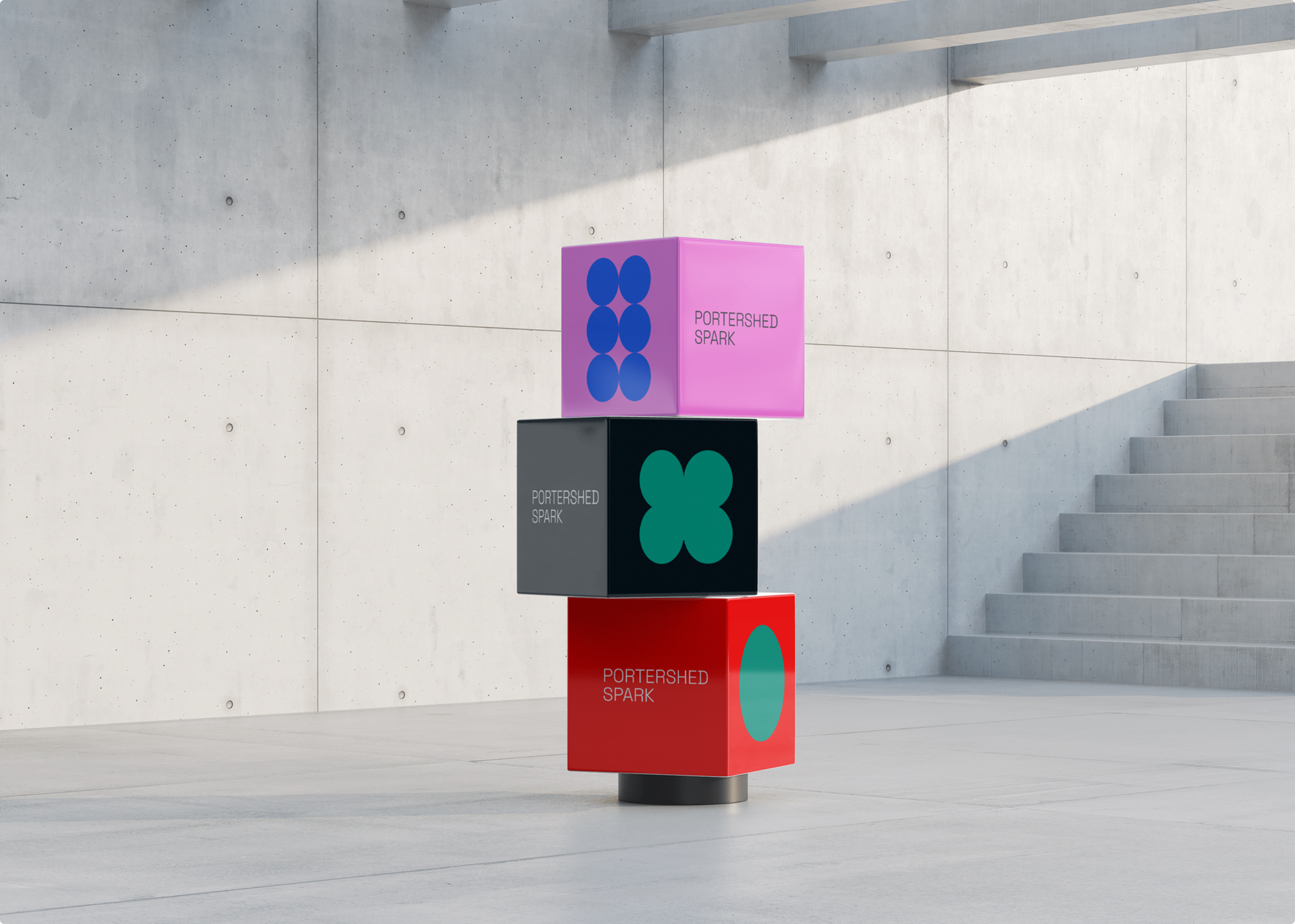 Three colorful cubes, inspired by Simpl by Rob&Paul, are stacked vertically in a modern, minimalist concrete space. The red, black, and pink cubes feature Portershed Spark text and bold graphic shapes. Steps appear on the right.